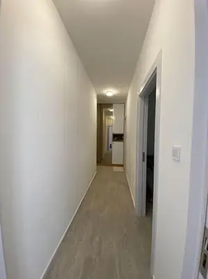 a hallway with white walls and a hallway with a door at Becici - apartment Majestic in Budva