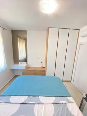 a bedroom with a blue bed and a mirror at Becici - apartment Majestic in Budva