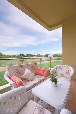 a couch and two chairs on a porch with a table at Apartments Aleksandra in Podgorica