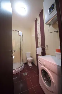 a bathroom with a washing machine and a toilet at Apartments Aleksandra in Podgorica