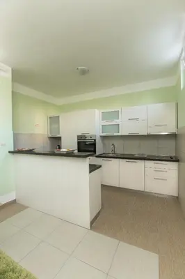 a kitchen with white cabinets and a counter top at Apartments Aleksandra in Podgorica