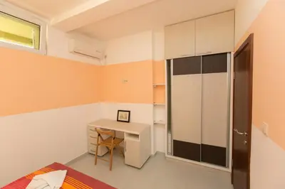 a small room with a desk and a closet at Apartments Aleksandra in Podgorica