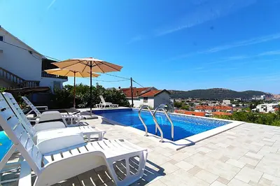 a swimming pool with white chairs and an umbrella at 2bd Apt w Private Pool and City View 
