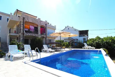 a swimming pool with chairs and an umbrella next to a building at 2bd Apt w Private Pool and City View 