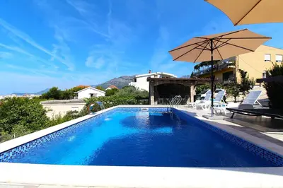 a swimming pool with an umbrella and chairs at 2bd Apt w Private Pool and City View 