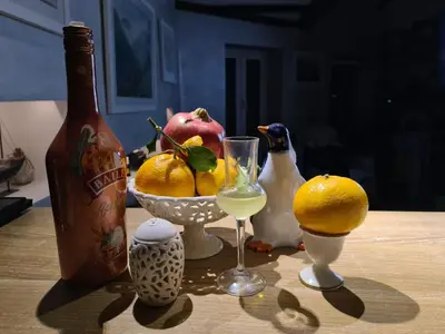 a table with a bottle of wine and a bowl of fruit at Черногория Квартира у моря in Rafailovici