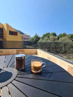 a cup of coffee on a table on a balcony at Черногория Квартира у моря in Rafailovici