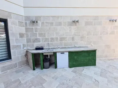 a kitchen with a counter and a sink in a brick wall at Черногория Квартира у моря in Rafailovici