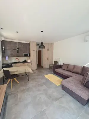 a living room with a couch and a table at Черногория Квартира у моря in Rafailovici