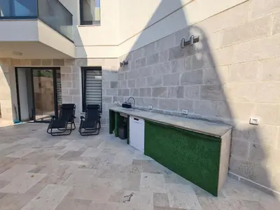 a patio with a sink and chairs next to a building at Черногория Квартира у моря in Rafailovici