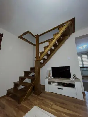 a living room with a staircase and a tv at Vikendica Silenzio in Cetinje