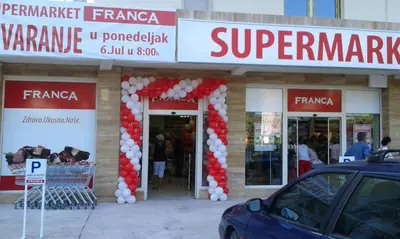 a store front with red and white balloons and a car parked outside at Studio Slavica in Budva