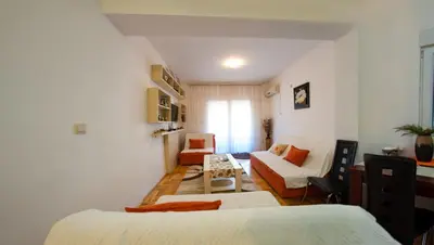 a hotel room with two beds and a couch at Studio Slavica in Budva