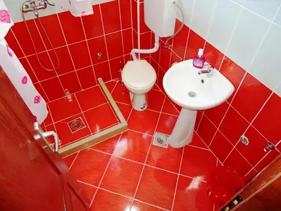 a red bathroom with a toilet and a sink at Apartments Nedovic-Jaz in Budva