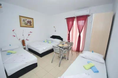 a room with two beds and a table and chairs at Apartments Nedovic-Jaz in Budva