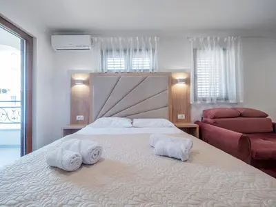 a bedroom with a large white bed with towels on it at Apartments Mary in Budva