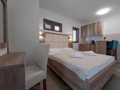 a bedroom with a bed and a table and a chair at Apartments Mary in Budva