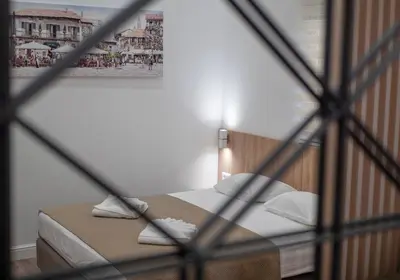 a bedroom with a bed with a framed picture on the wall at Apartments Mary in Budva