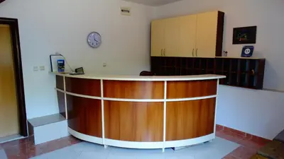 a counter in a room with a clock on the wall at Blue Palace Guest House in Budva