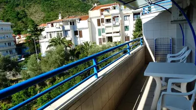 a balcony with a table and chairs and buildings at Blue Palace Guest House in Budva