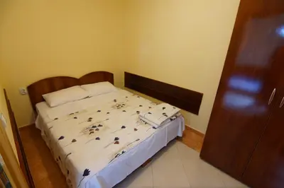 a bedroom with a bed with a wooden headboard at Blue Palace Guest House in Budva