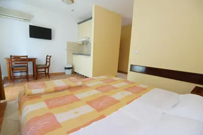 a bedroom with a bed and a kitchen and a table at Blue Palace Guest House in Budva