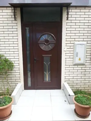 a brown door on a house with two plants at Apartments Krivokapic in Kotor