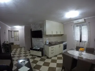 a kitchen and living room with a table and a kitchen gmaxwell gmaxwell gmaxwell at Apartments Krivokapic in Kotor