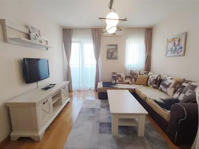 a living room with a couch and a tv at CITY POINT Apartment in Podgorica