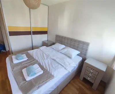 a bedroom with a white bed with towels on it at CITY POINT Apartment in Podgorica