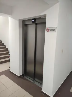 two elevator doors in a building with a sign on it at CITY POINT Apartment in Podgorica