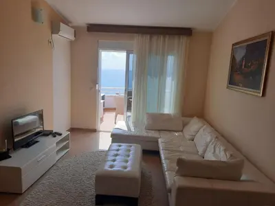 a living room with a couch and a television at Apartments Val in Dobra Voda