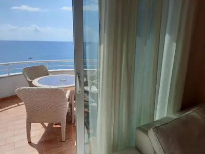 a balcony with a view of the ocean from a hotel room at Apartments Val in Dobra Voda