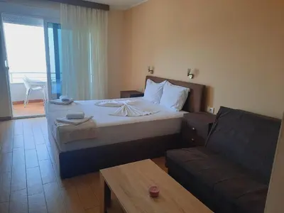a bedroom with a large bed and a couch at Apartments Val in Dobra Voda