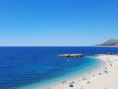 a group of people on a beach in the ocean at Apartments Val in Dobra Voda
