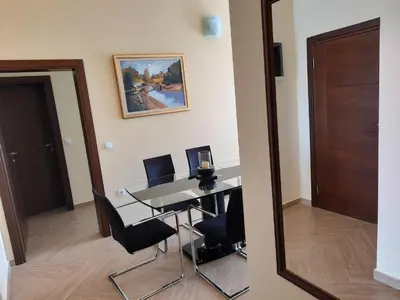 a dining room with a table and chairs and a mirror at Apartments Val in Dobra Voda