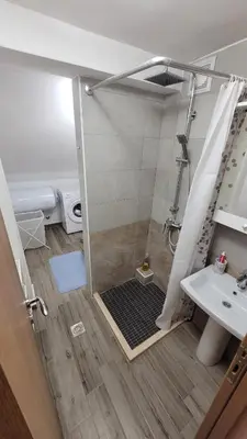 a shower with a glass door next to a sink at Apartment Old Olive in Dobra Voda