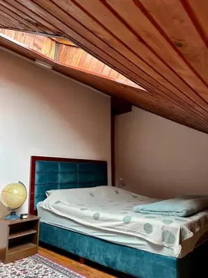 a bed in a bedroom with a wooden ceiling at Central Park Apartment in Podgorica