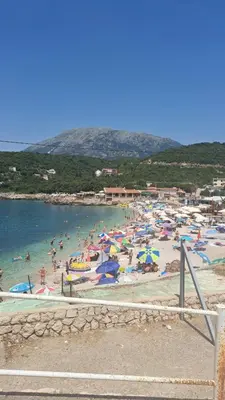 a group of people on a beach with umbrellas at Apartman Marinamar in Utjeha