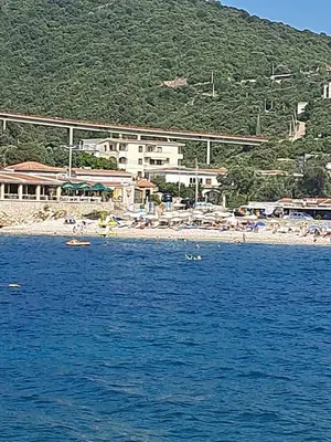 a group of people swimming in the water at a beach at Apartman Marinamar in Utjeha