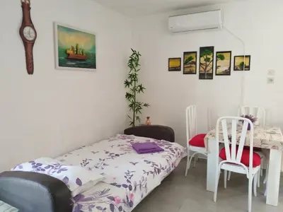 a bedroom with a bed and a table and chairs at Apartman Marinamar in Utjeha