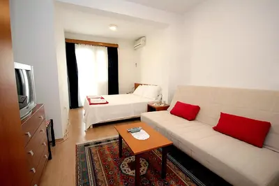 a living room with a couch and a bed at Guesthouse Drašković in Petrovac na Moru