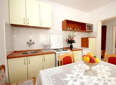 a kitchen with a table with a bowl of fruit on it at Guesthouse Drašković in Petrovac na Moru