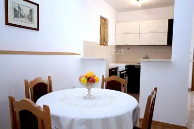 a kitchen with a table with a bowl of fruit on it at Guesthouse Drašković in Petrovac na Moru