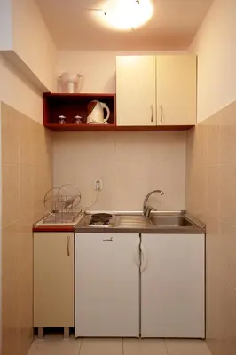 a kitchen with white cabinets and a sink at Guesthouse Drašković in Petrovac na Moru