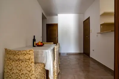 a dining room table with chairs and a bottle of wine at Guesthouse Drašković in Petrovac na Moru