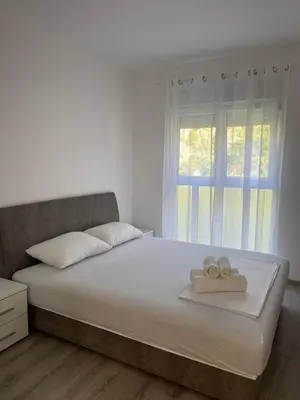 a bedroom with a bed with two towels on it at Orlando apartman in Kotor