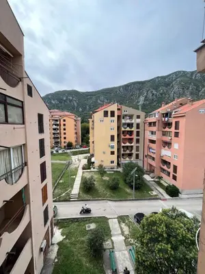 a city with buildings and a mountain in the background at Orlando apartman in Kotor