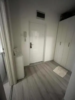 an empty room with a white door and wooden floors at Orlando apartman in Kotor