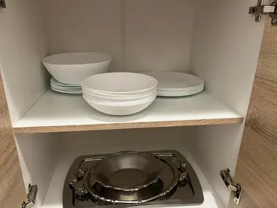 a kitchen with plates and bowls on a shelf at Orlando apartman in Kotor